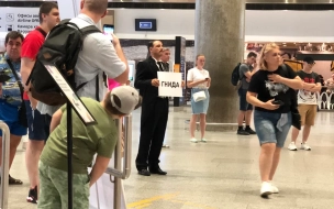 В аэропорту Пулково мужчина в черном фраке встречал с табличкой "гнидА" прибывших людей в Петербург