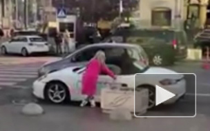 Видео из Киева: Блондинка в розовом порубила "Порше" топором