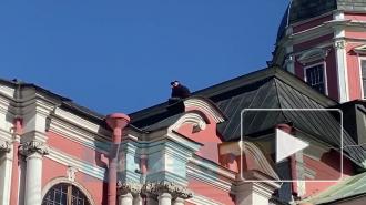 Очевидцы сняли на видео мужчину, который забрался на крышу Александро-Невской Лавры с ножом